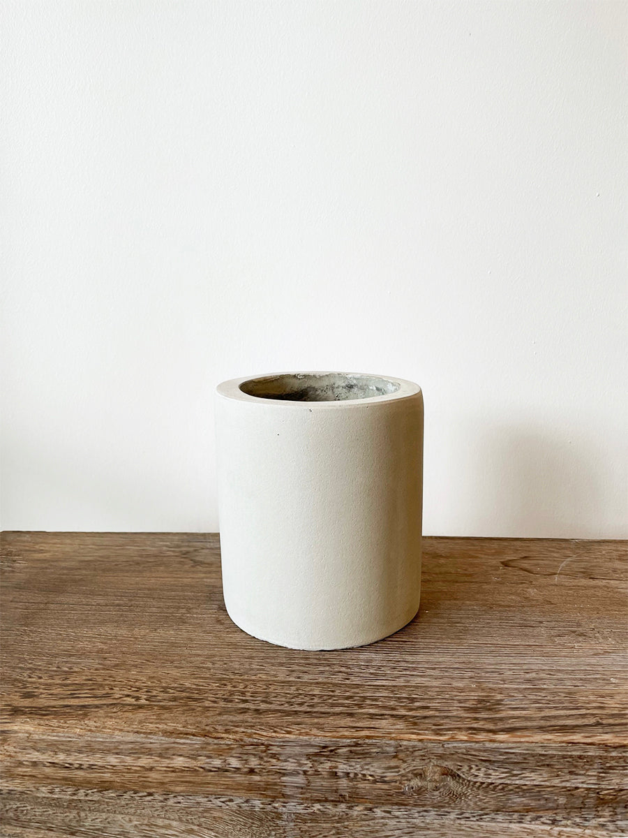Elegant lille betonkrukke i rå cement med dimensionerne Ø15 x H17 cm, perfekt til små planter som orkidéer og sukkulenter. Anvendelig både indendørs og udendørs.