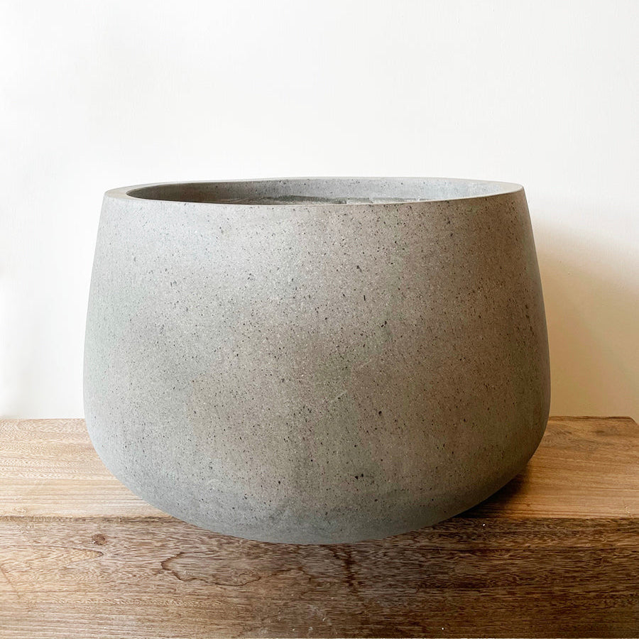 Lav, bred COAL krukke i rå grå beton, Ø65 cm x H40 cm, perfekt til store planter indendørs og udendørs, med rustikt design.